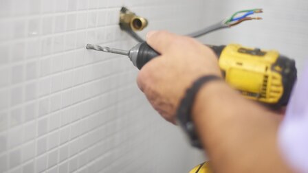 Versteckte Asbest-Gefahr: Handwerker beim Bohren in Fliesen